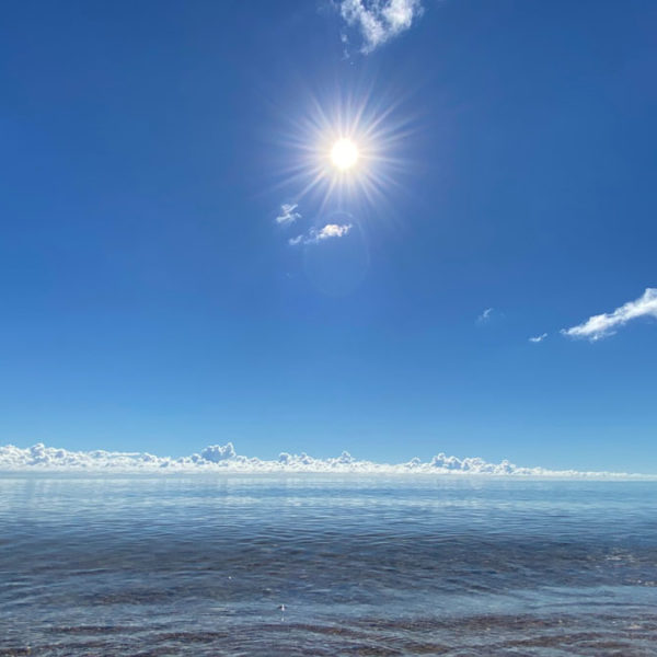 sun and clouds near water